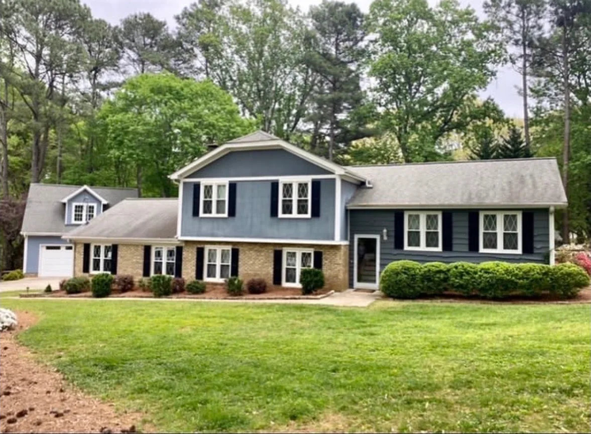 Split-level home with freshly painted blue-gray siding, white trim and black shutters