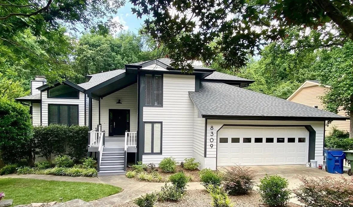 Contemporary home with freshly painted light gray siding and dark trim